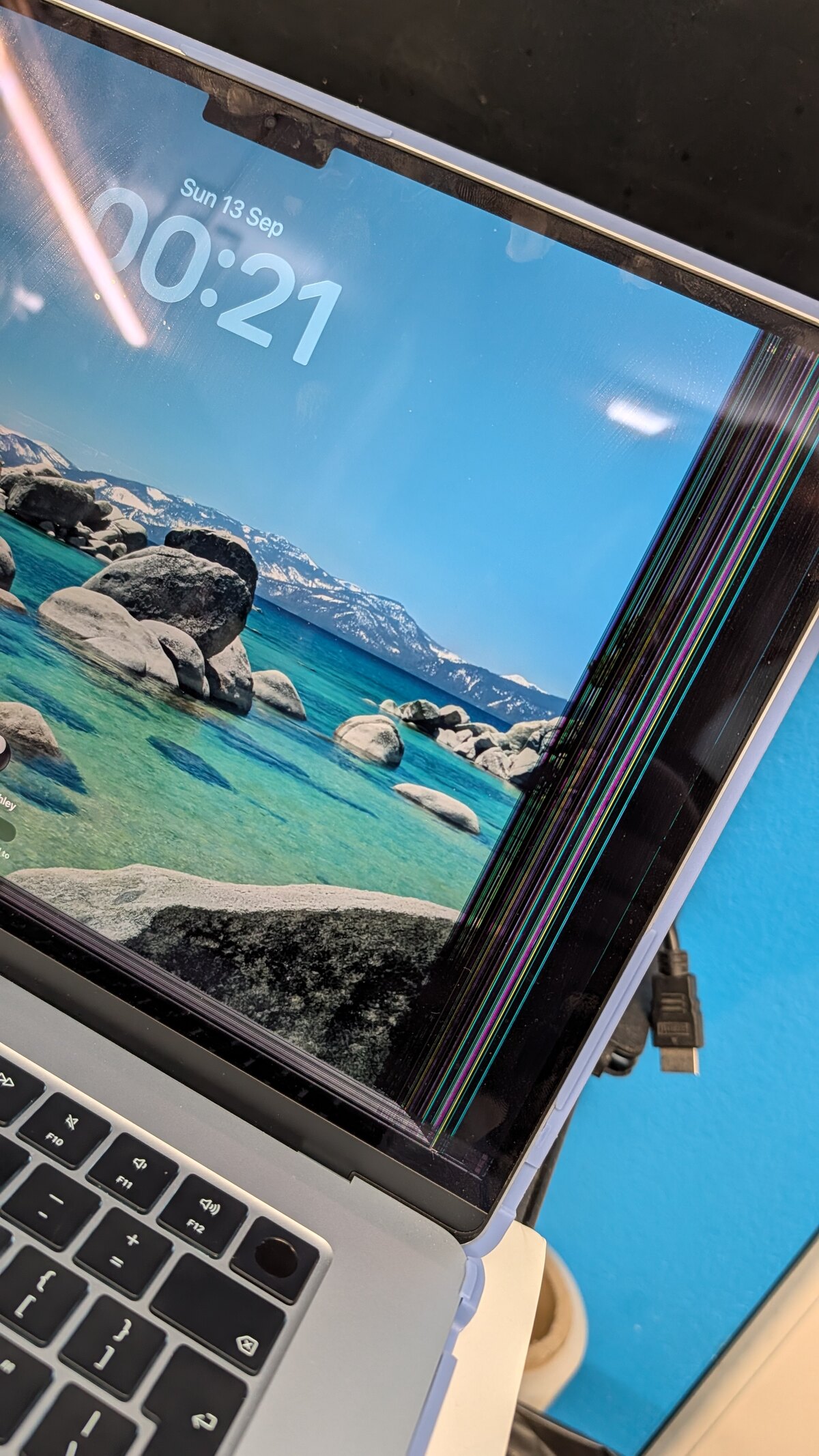 2025 MacBook with a cracked display and coloured lines across the screen